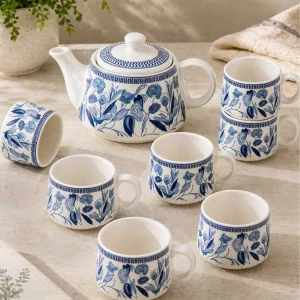 Elegant blue floral ceramic tea set with teapot and matching cups arranged in a minimal aesthetic kitchen setup
