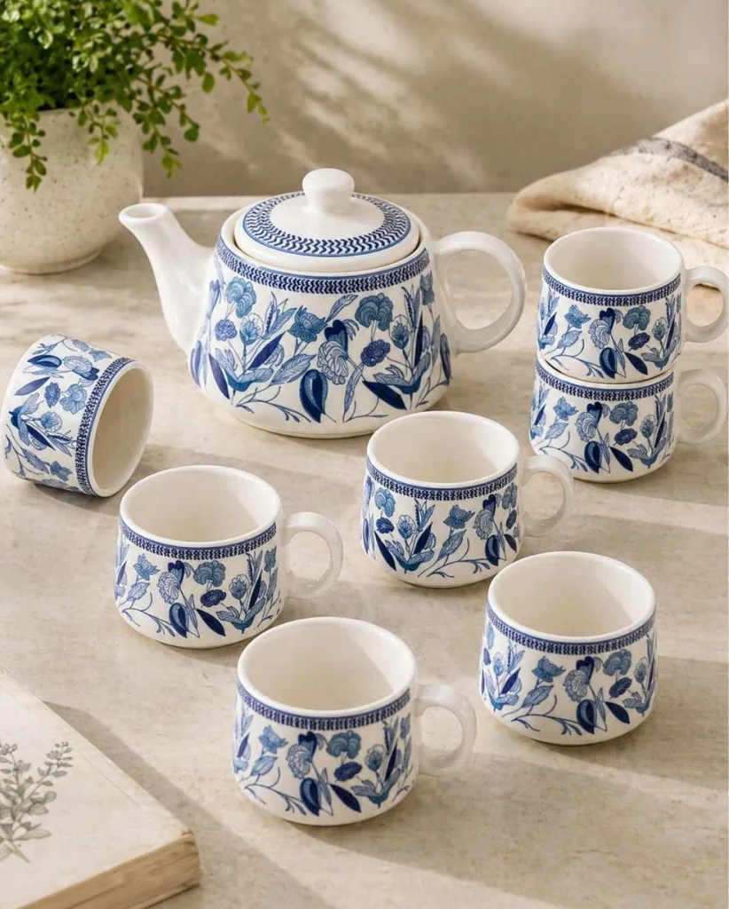 Elegant blue floral ceramic tea set with teapot and matching cups arranged in a minimal aesthetic kitchen setup