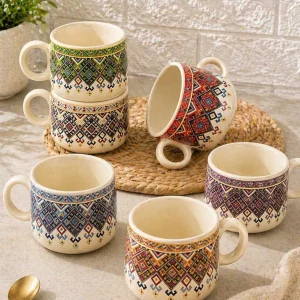 Colorful bohemian tribal print ceramic mugs with geometric patterns arranged in an aesthetic kitchen setup