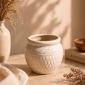 Ivory textured ceramic planter pot with geometric design on marble surface aesthetic home decor