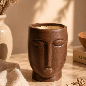 Teal glossy ceramic planter pot on marble surface with warm aesthetic home decor setup