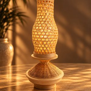 Handwoven bamboo table lamp glowing warmly on a wooden table at night